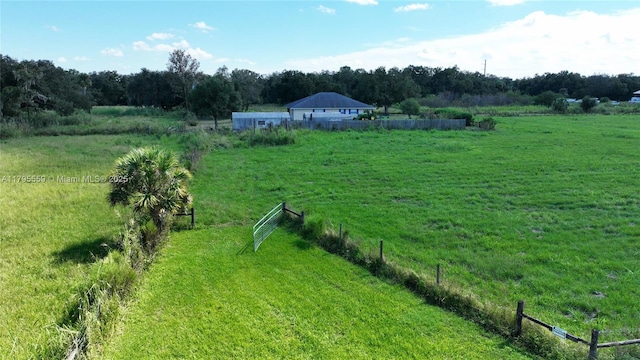 view of yard with fence and a rural view