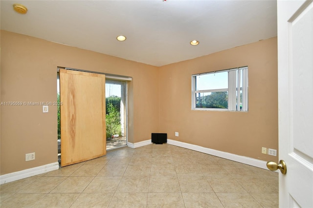 empty room with baseboards, tile patterned floors, and recessed lighting