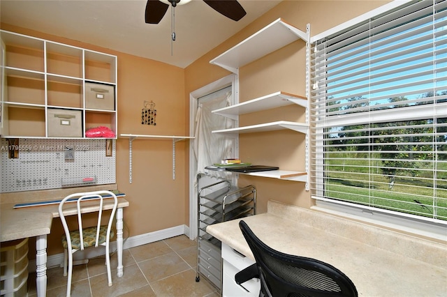 tiled home office featuring built in desk, baseboards, and ceiling fan
