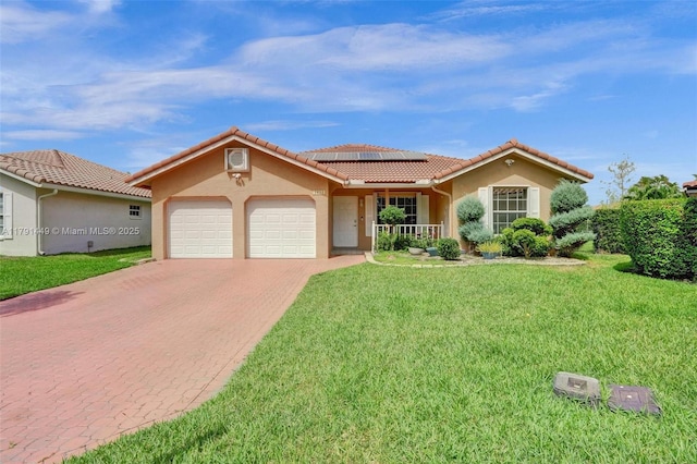 mediterranean / spanish-style house with a garage, stucco siding, roof mounted solar panels, and decorative driveway