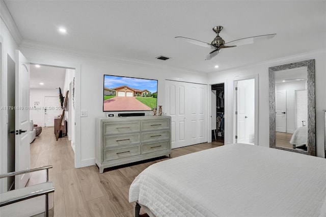 bedroom featuring ornamental molding, light wood finished floors, and visible vents