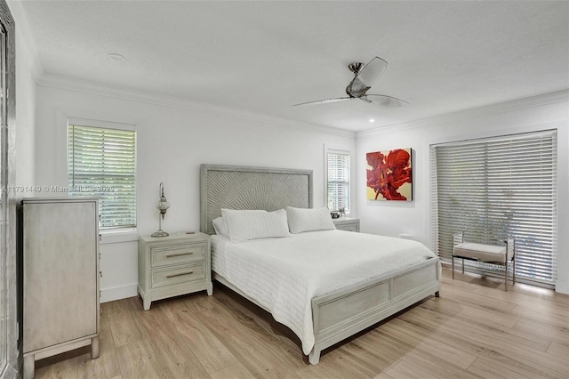 bedroom featuring light wood-type flooring, ornamental molding, baseboards, and multiple windows
