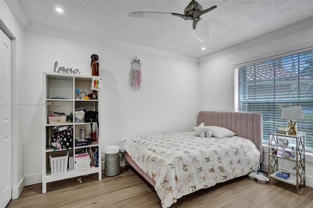bedroom with crown molding, ceiling fan, and wood finished floors