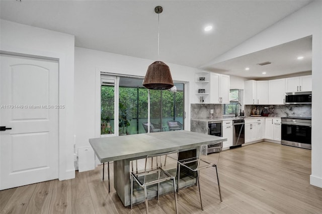 kitchen with appliances with stainless steel finishes, tasteful backsplash, open shelves, a sink, and beverage cooler