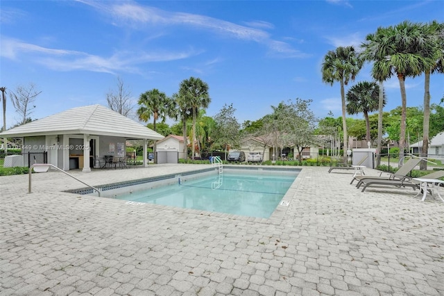 pool with a patio area and fence