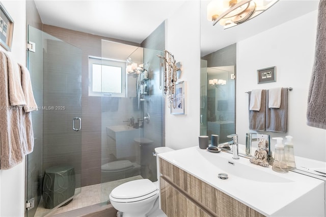 bathroom with vanity, a shower stall, and toilet