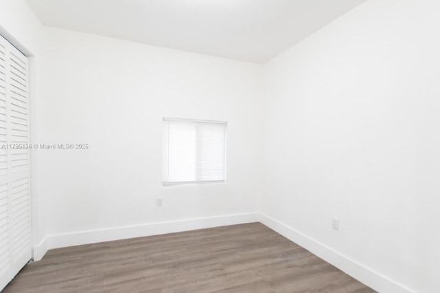 empty room featuring baseboards and wood finished floors