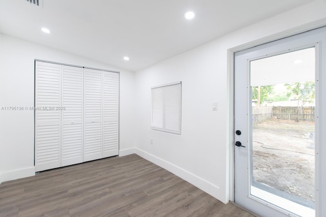 interior space featuring access to outside, baseboards, recessed lighting, and wood finished floors