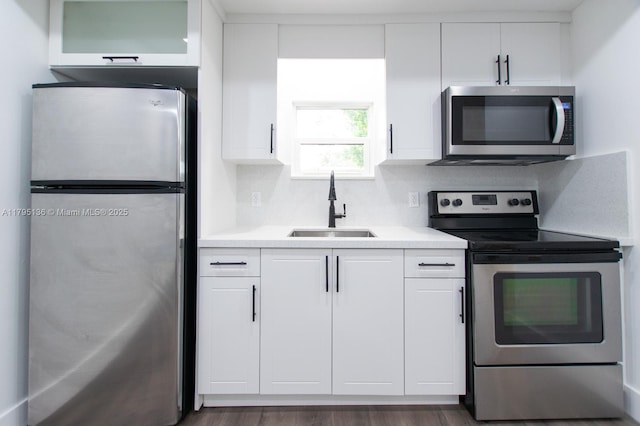 kitchen featuring light countertops, a sink, white cabinetry, and stainless steel appliances