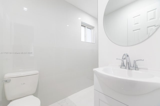bathroom featuring vanity, toilet, and marble finish floor