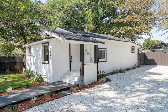 view of front facade with fence and stucco siding