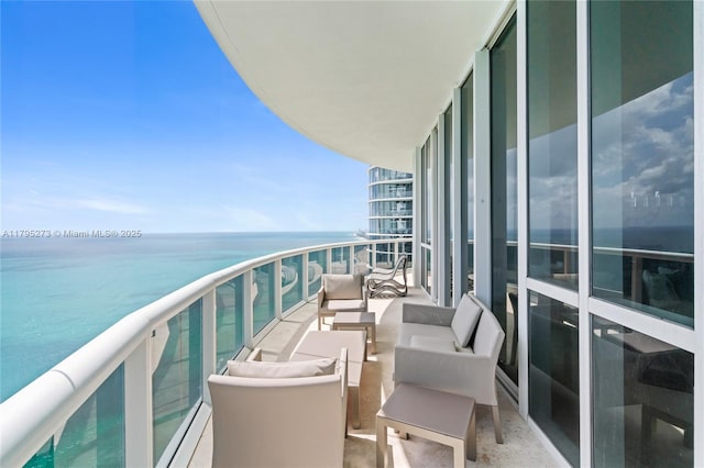 balcony featuring a water view and outdoor lounge area