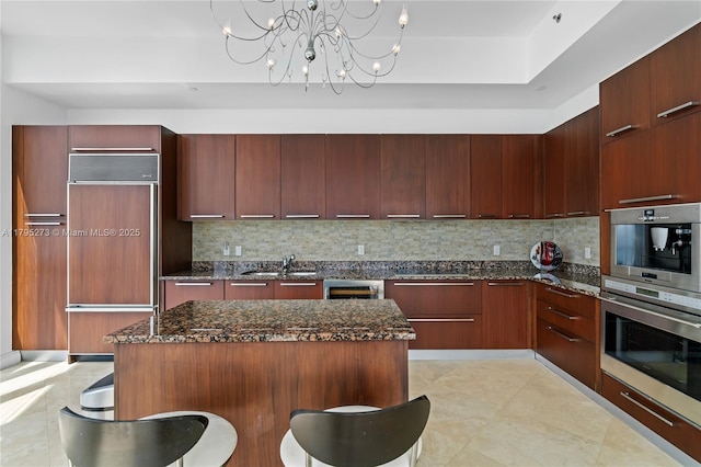 kitchen featuring paneled refrigerator, modern cabinets, and a breakfast bar