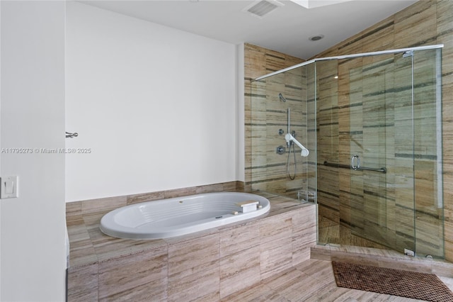 full bath featuring a stall shower, a garden tub, and visible vents