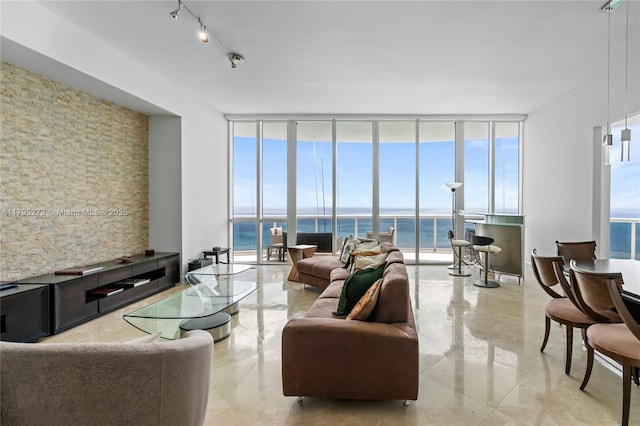 living area with a water view, floor to ceiling windows, and track lighting