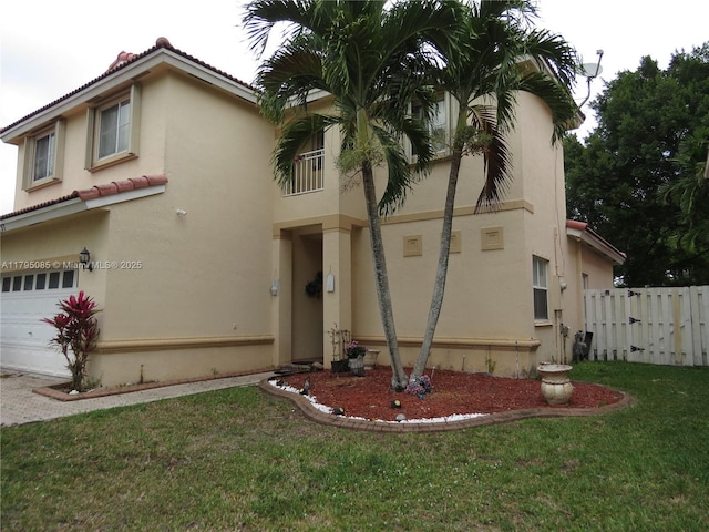 mediterranean / spanish-style house with an attached garage, a front lawn, a tile roof, and stucco siding