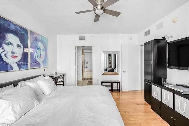 bedroom featuring a ceiling fan, visible vents, and light wood finished floors