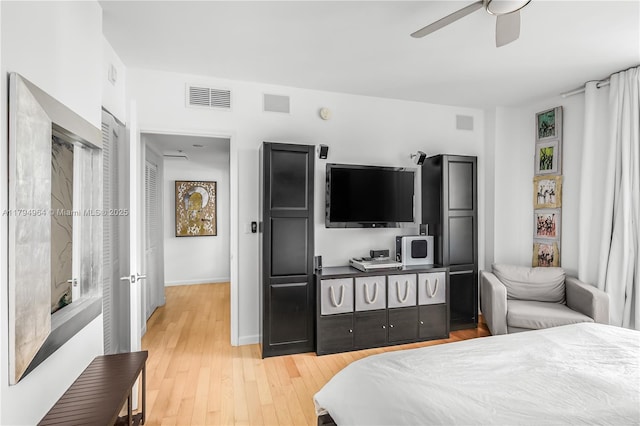 bedroom featuring visible vents, a ceiling fan, baseboards, and light wood-type flooring