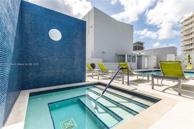 pool featuring a hot tub and a patio