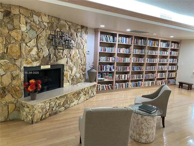 4133 S Carambola Cir S Unit G203, Coconut Creek, FL 33066 - living area featuring wood finished floors, bookshelves, and a stone fireplace