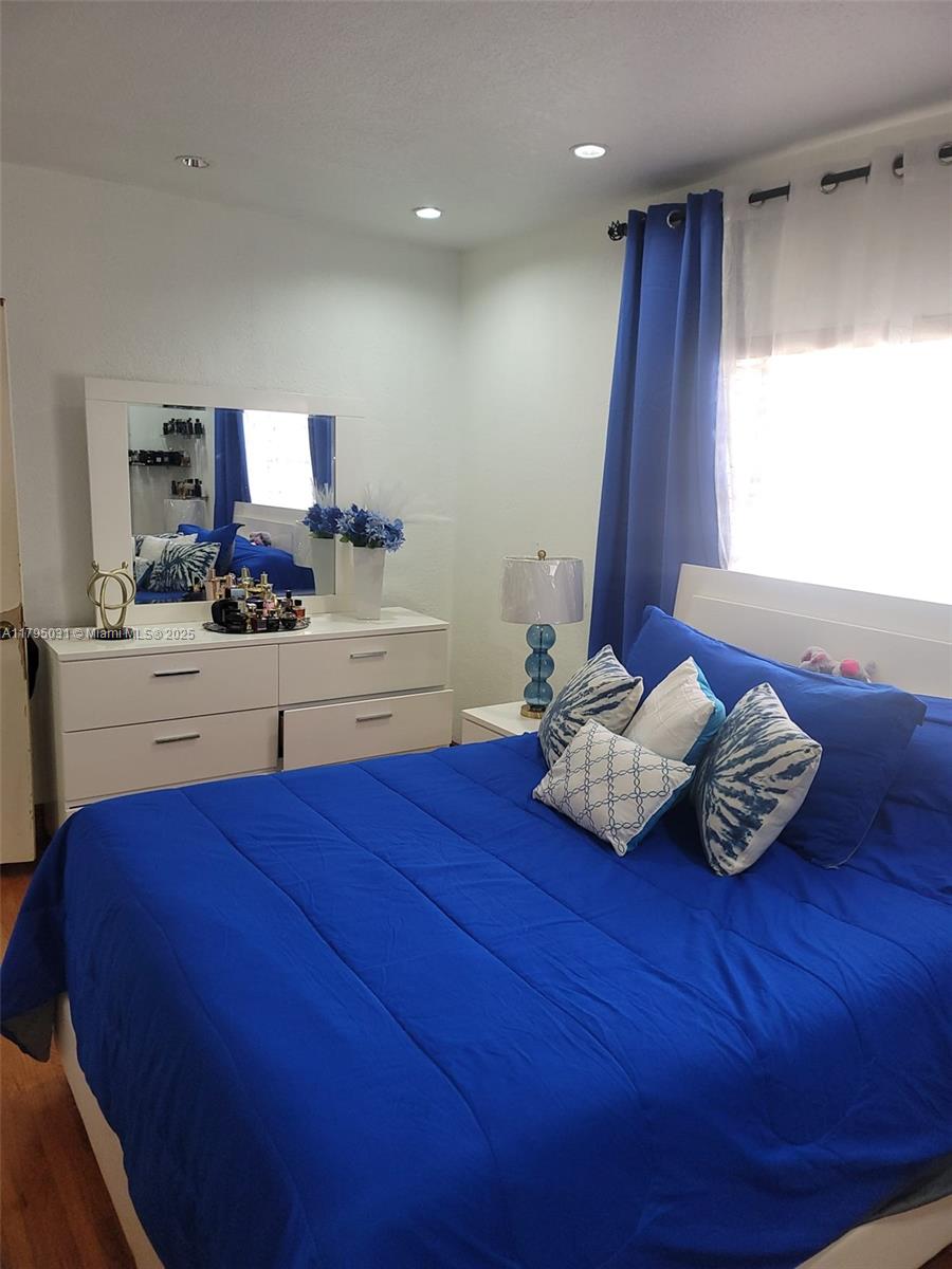bedroom with wood finished floors and recessed lighting