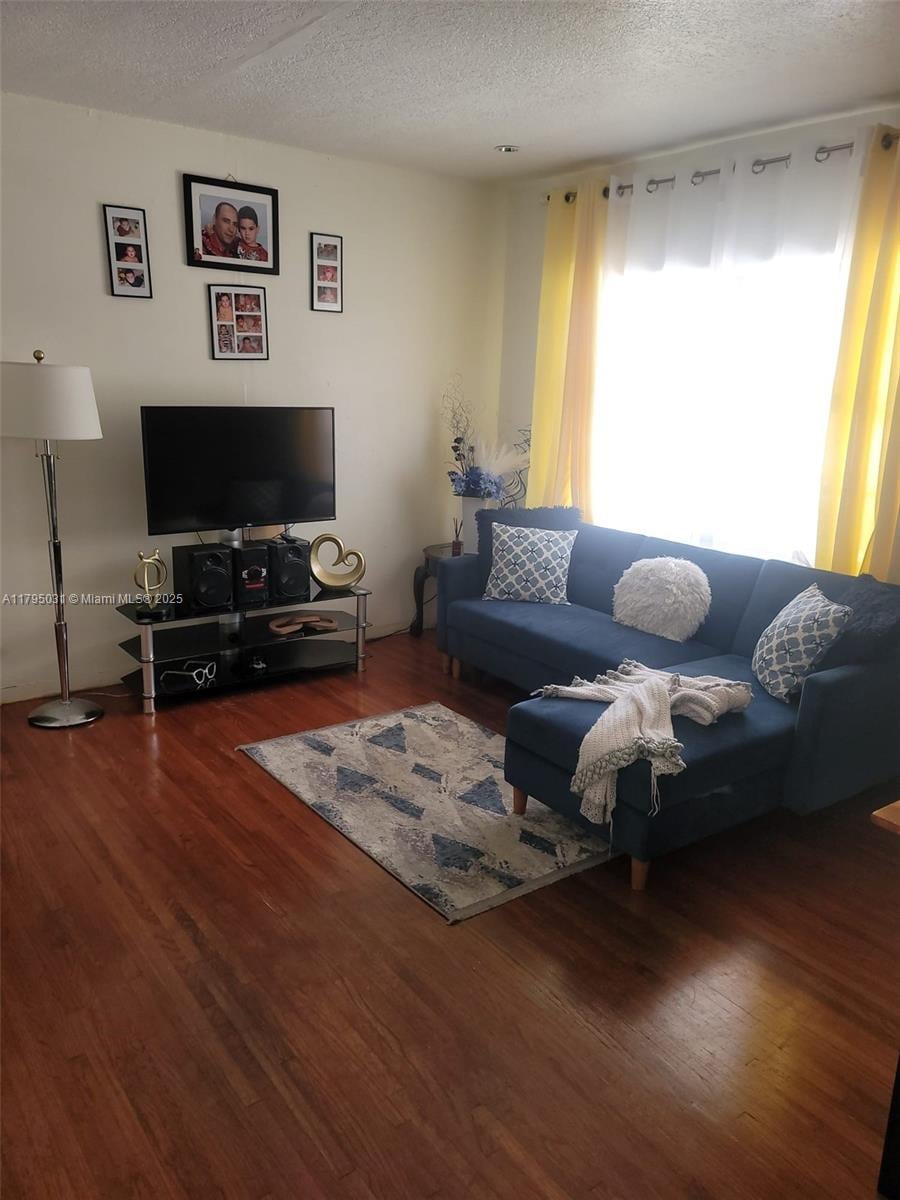 living room featuring wood finished floors and a textured ceiling