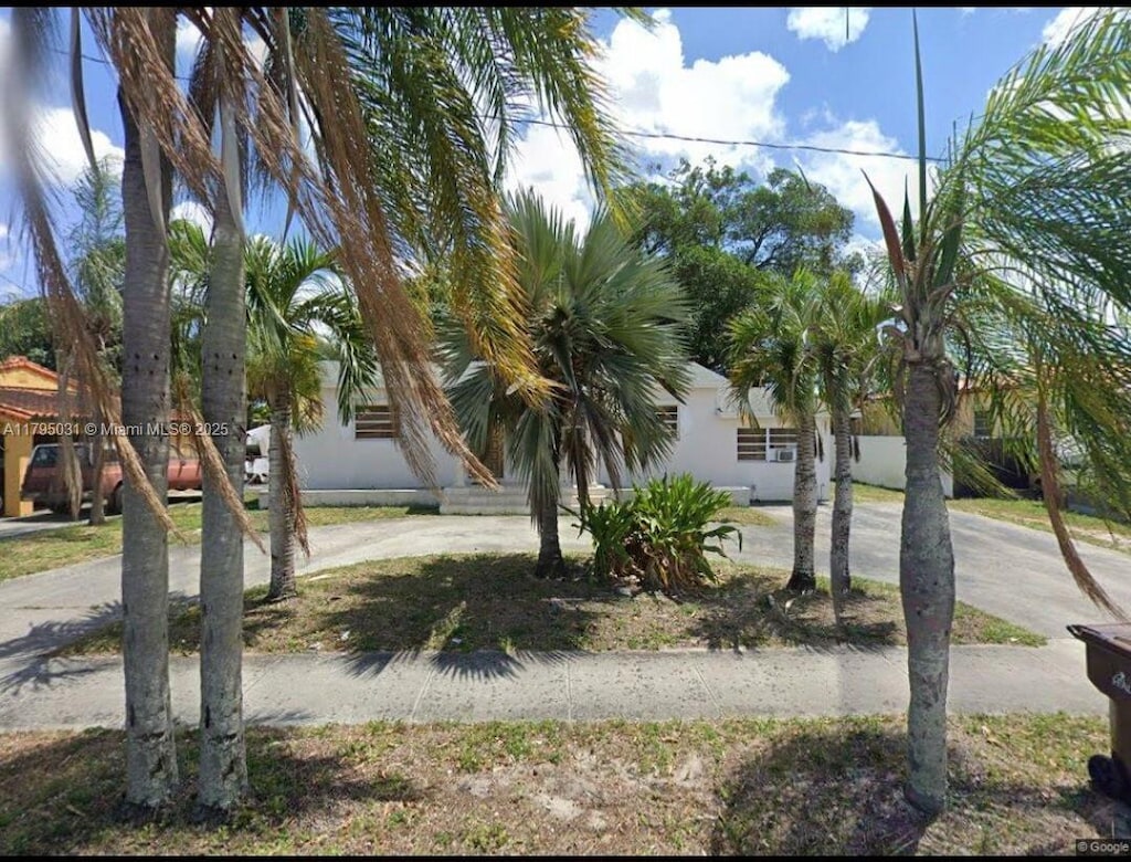 obstructed view of property with concrete driveway