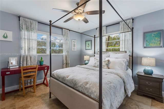 bedroom featuring baseboards, ceiling fan, and multiple windows