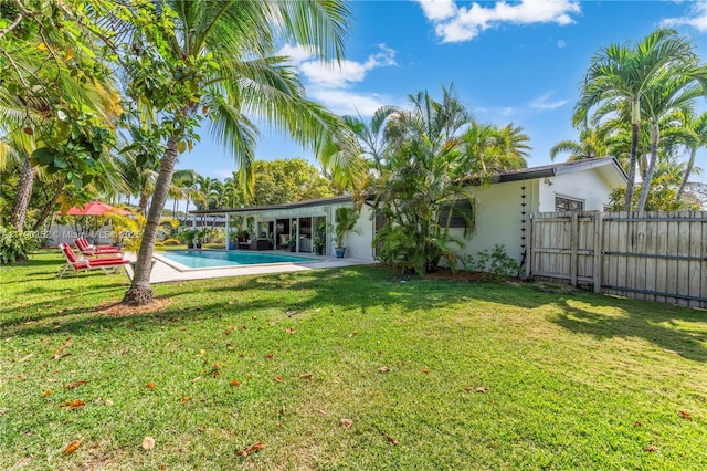 back of house with a fenced in pool, stucco siding, a yard, and fence