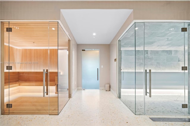 hallway with recessed lighting, baseboards, and speckled floor