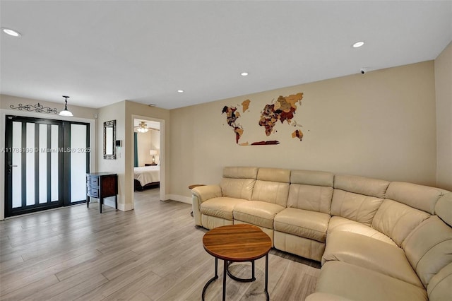 living room with baseboards, recessed lighting, and light wood-type flooring