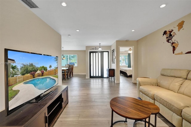 living area with light wood-style floors, recessed lighting, baseboards, a ceiling fan, and visible vents