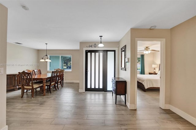 foyer entrance with baseboards, light wood-style flooring, and visible vents
