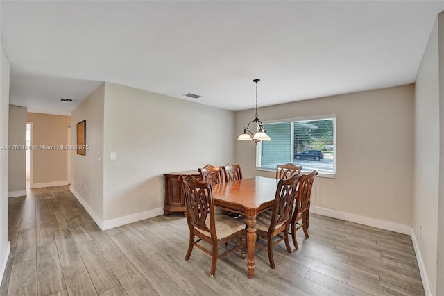 dining room featuring baseboards, light wood-type flooring, and visible vents