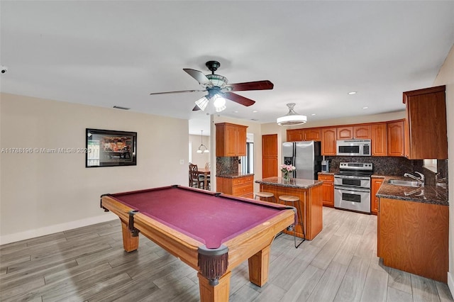 playroom featuring a ceiling fan, visible vents, a sink, and light wood-style floors