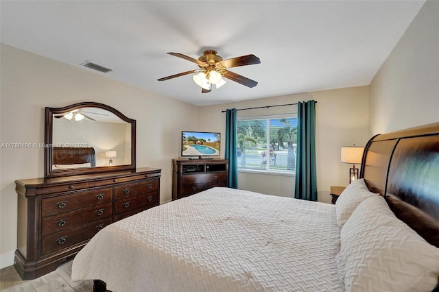 bedroom featuring ceiling fan, visible vents, and light wood finished floors