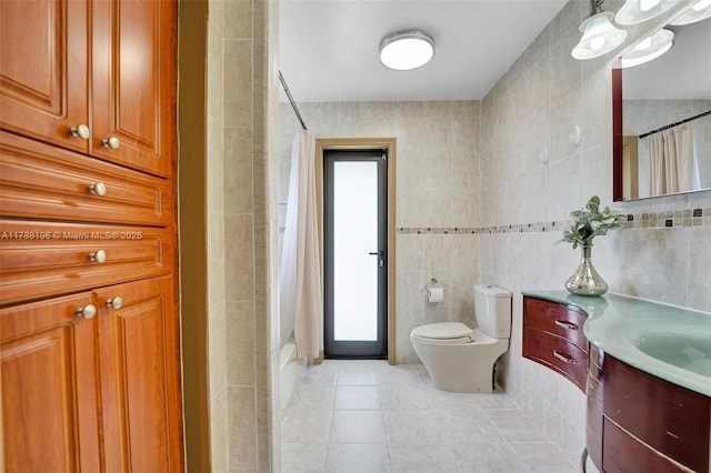 full bathroom featuring toilet, tile walls, tile patterned flooring, and vanity