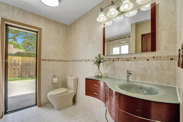 bathroom featuring vanity, tile walls, toilet, and tile patterned floors