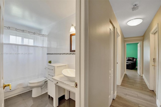 full bath featuring vanity, shower / tub combo, and toilet