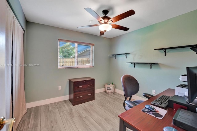 office area featuring baseboards, a ceiling fan, and light wood-type flooring