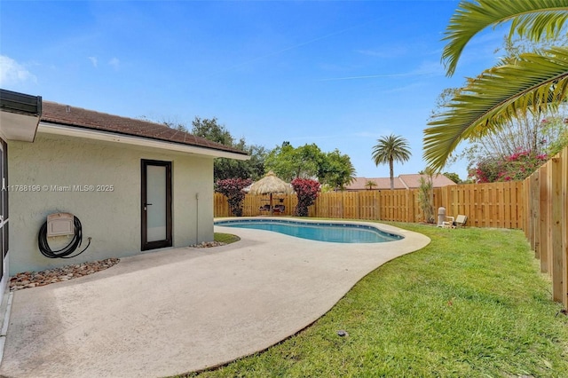 view of swimming pool featuring a fenced backyard, a fenced in pool, a yard, and a patio area