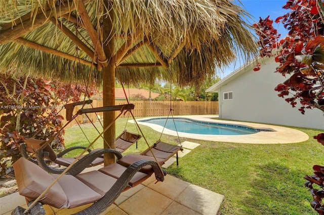 view of swimming pool featuring a fenced backyard, a fenced in pool, a yard, and a patio