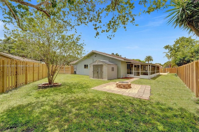 rear view of house featuring a fenced backyard, a patio, a sunroom, and an outdoor fire pit