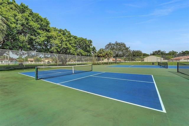 view of tennis court featuring fence and community basketball court