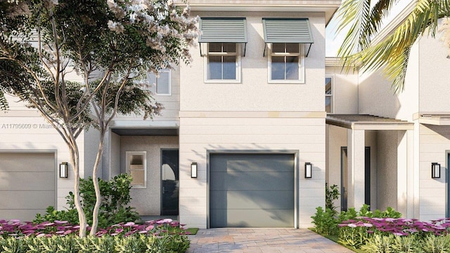 view of front of house with a garage, stucco siding, and driveway