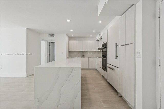 9 Island Ave Unit 1209, Miami Beach, FL 33139 - kitchen featuring double wall oven, visible vents, recessed lighting, a center island, and modern cabinets
