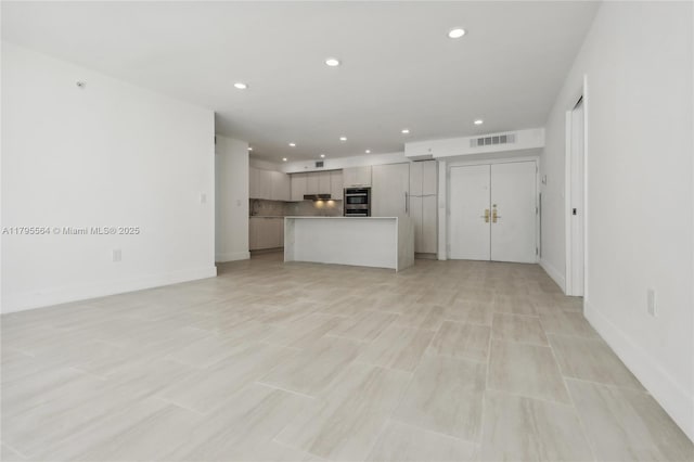 unfurnished living room with baseboards, visible vents, and recessed lighting