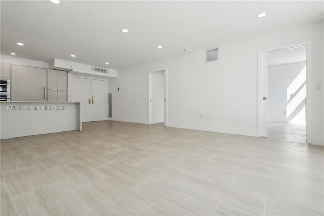 unfurnished living room featuring visible vents and recessed lighting