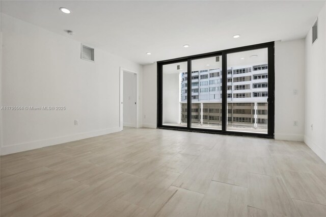 9 Island Ave Unit 1209, Miami Beach, FL 33139 - empty room with light wood finished floors, recessed lighting, visible vents, and floor to ceiling windows