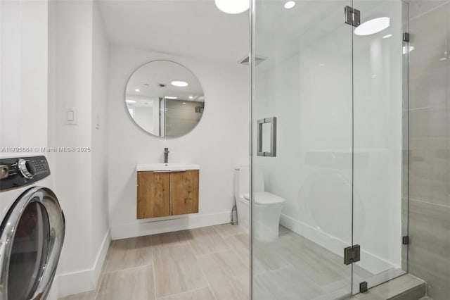 full bath featuring a stall shower, washer / clothes dryer, baseboards, and vanity